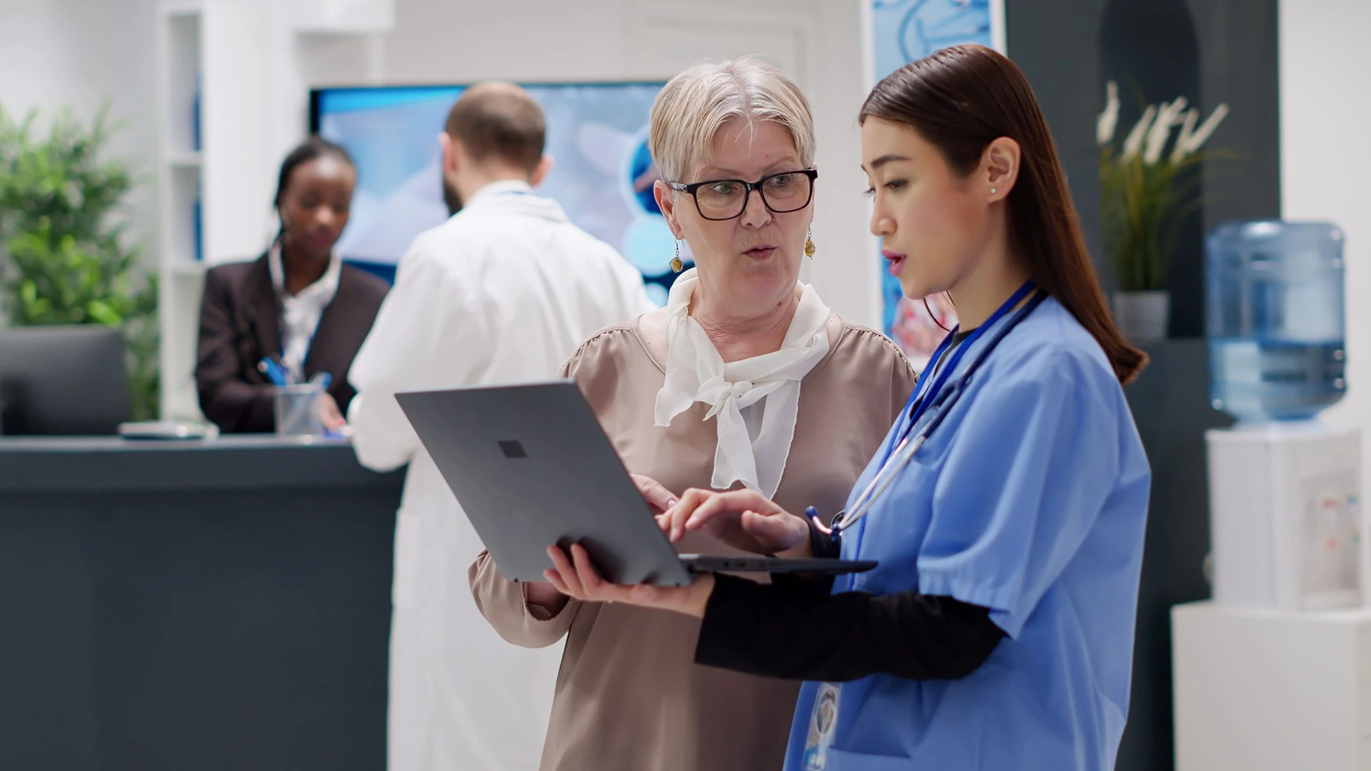 Healthcare resume writers helping a nurse on a laptop.